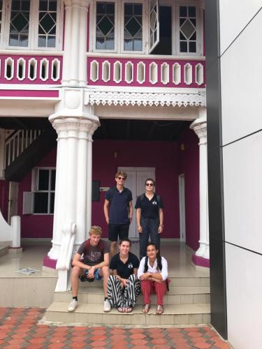 a group of people sitting on the steps of a house at Palm Rivera Kochi in Cochin