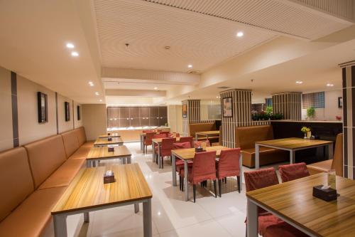 a restaurant with wooden tables and red chairs at Jinjiang Inn - Beijing Changchun Street in Beijing
