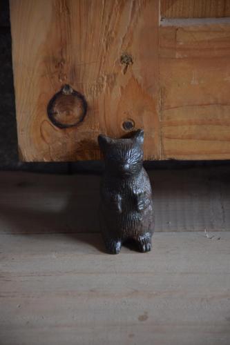 a black cat statue sitting next to a wooden door at Kudrat - A Boutique Homestay- Tirthan Valley in Banjār