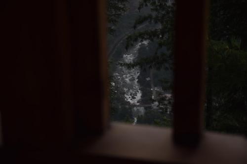 a window with a view of a mountain at Kudrat - A Boutique Homestay- Tirthan Valley in Banjār