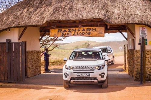 a white car parked in front of a building at Rain Farm Game Lodge in uMhlali