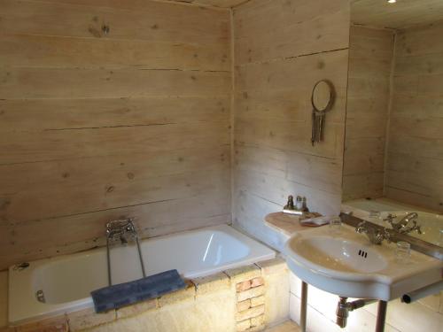 une salle de bain avec une baignoire et un lavabo dans l'établissement La Santoline, à Beaulieu