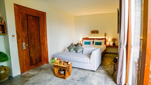 a bedroom with a white bed and a wooden door at Sarina Boutique Hotel in Phnom Penh