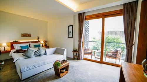 a living room with a white couch and a large window at Sarina Boutique Hotel in Phnom Penh