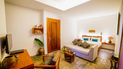 a living room with a couch and a tv at Sarina Boutique Hotel in Phnom Penh