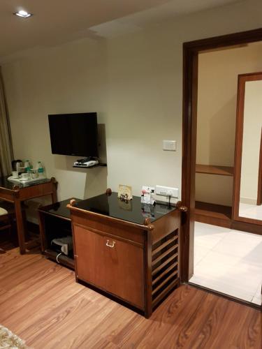 a room with a desk and a tv on the wall at Hotel Polo Towers Shillong in Shillong