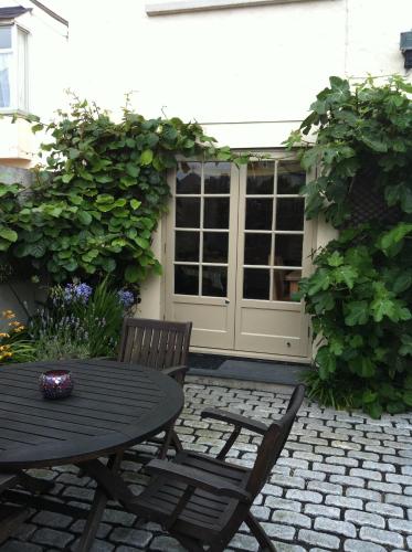 a patio with a table and chairs and a window at Fistral Court in Newquay