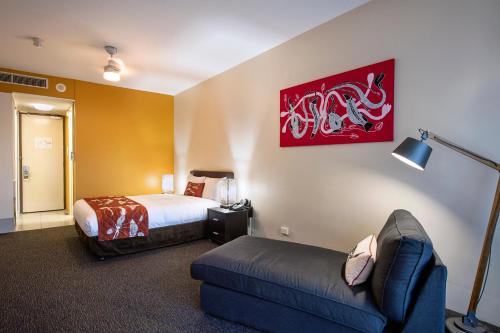 a hotel room with a bed and a couch at Mercure Kakadu Crocodile in Jabiru