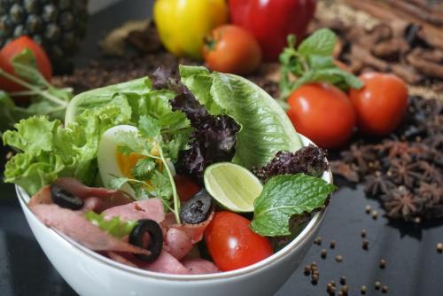 a salad in a bowl with tomatoes and lettuce at Grand Keisha Yogyakarta in Yogyakarta