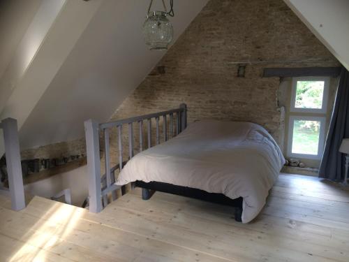 Domaine saint-martin d Amfreville في Amfréville: غرفة نوم بسرير في العلية