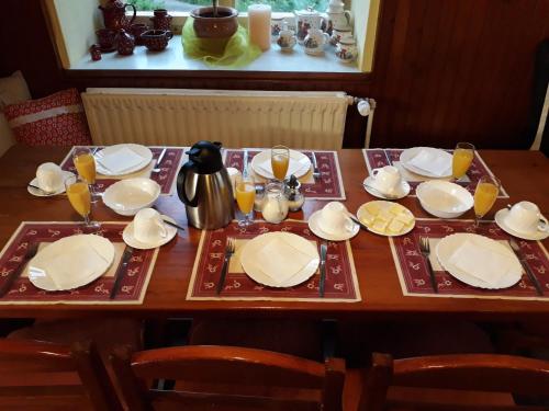 a wooden table with plates and glasses of orange juice at Ubytování - U nás doma in Orličky