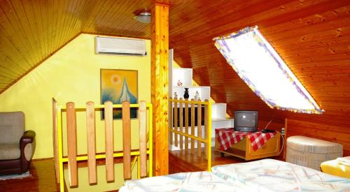 a bedroom with a crib and a tv in a room at Unicum Vendégház in Abádszalók