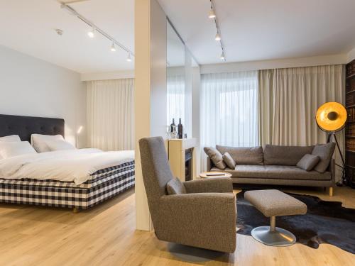 a bedroom with a bed and a couch and a chair at Original Sokos Hotel Kaarle Kokkola in Kokkola