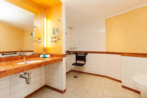 a bathroom with a sink and a toilet at Vienna House by Wyndham Remarque Osnabrück in Osnabrück