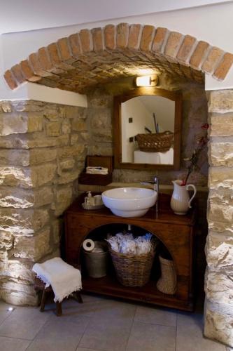 a stone bathroom with a sink and a mirror at Casa Vacanza Gaia in Costa di Mezzate