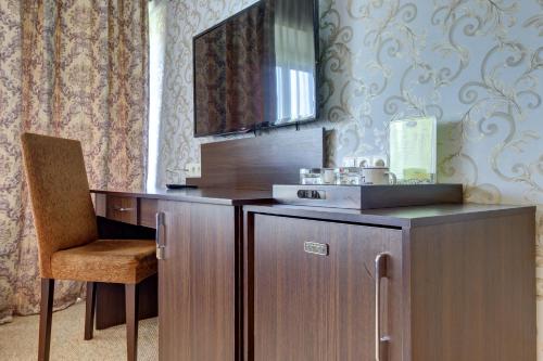 a wooden desk with a chair and a mirror at Premier Alatau Hotel in Almaty