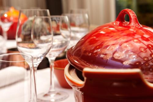 a table with wine glasses and a red bowl on it at Vienna House by Wyndham Remarque Osnabrück in Osnabrück