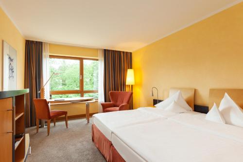 a hotel room with a bed and a desk at Vienna House by Wyndham Remarque Osnabrück in Osnabrück