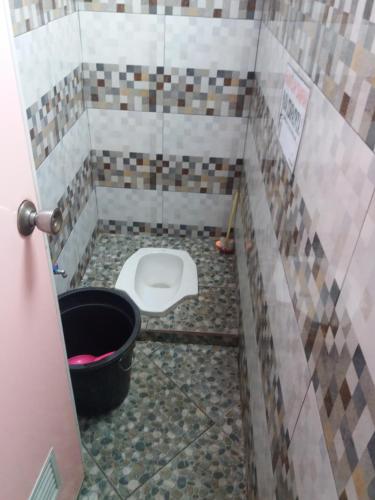 a small bathroom with a toilet in a stall at Budhis Home in Bromo
