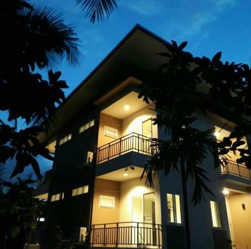 a large building with a balcony at night at Baan Glangsuan Bang Kobua in Bang Chak