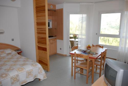 a bedroom with a bed and a table with a television at Azureva Bussang in Bussang