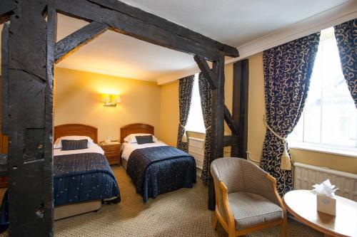 ein Hotelzimmer mit 2 Betten und einem Tisch in der Unterkunft Prince Rupert Hotel in Shrewsbury