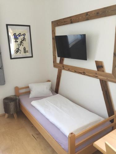 ein Schlafzimmer mit einem Etagenbett und einem Flachbild-TV in der Unterkunft Ferienwohnungen Ellmer in Flachau