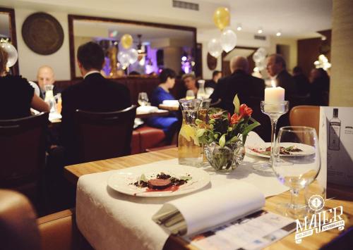 a table in a restaurant with a plate of food at Hotel Silvia Gold Gliwice in Gliwice