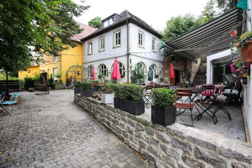 a building with a patio with tables and chairs at Hotel-Restaurant Buger Hof in Bamberg