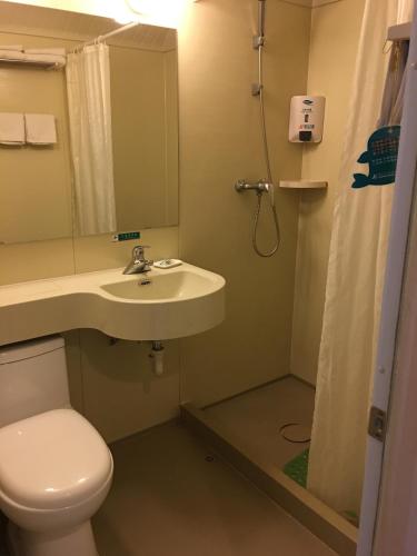 a bathroom with a toilet and a sink and a shower at Jinjiang Inn Beijing Liangxiang Nanguan Subway Station in Fangshan