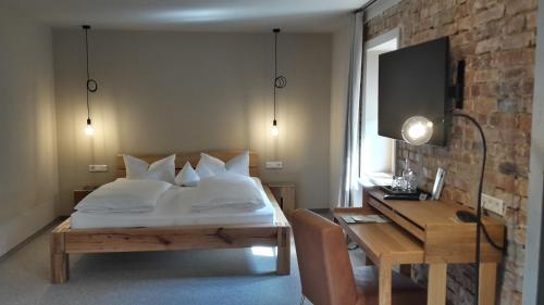 a bedroom with a bed and a table and a desk at Berghotel Sammüller in Neumarkt in der Oberpfalz