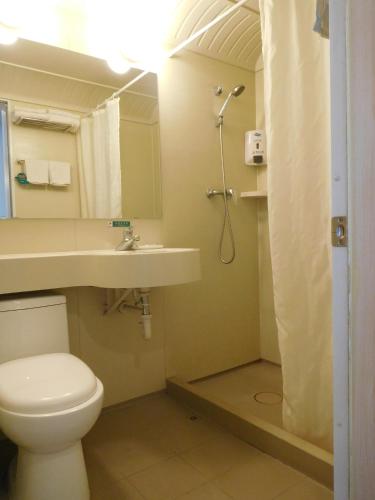 a bathroom with a toilet and a sink and a shower at Jinjiang Inn Beijing Liangxiang Nanguan Subway Station in Fangshan