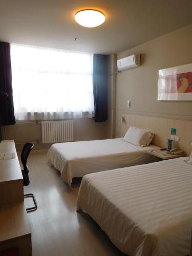 a hotel room with two beds and a window at Jinjiang Inn Beijing Liangxiang Nanguan Subway Station in Fangshan