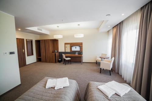 a hotel room with two beds and a desk at Hotel Wodnik in Bydgoszcz