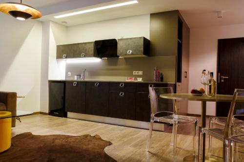 a kitchen with black cabinets and a table and chairs at Penzión v Inom Svete in Žilina