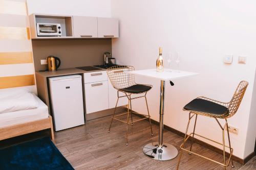 a small kitchen with a table and chairs in a room at Penzión v Inom Svete in Žilina