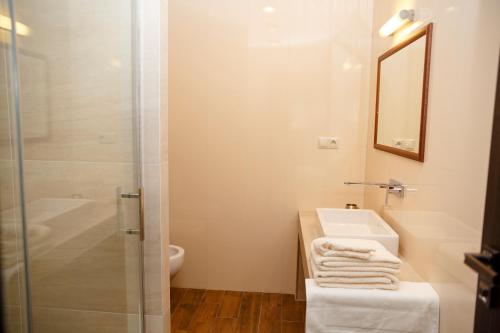 a bathroom with a shower and a sink and a mirror at Penzión v Inom Svete in Žilina
