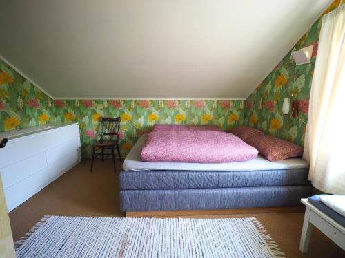 - une chambre avec un lit et un oreiller rose dans l'établissement Steinbakk - Vestresand Lofoten, à Bøstad