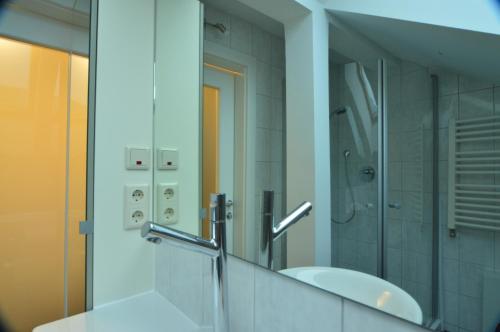 a bathroom with a sink and a mirror at Pension Elisabeth - Rooms & Apartments in Salzburg