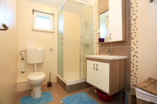 a bathroom with a toilet and a shower and a sink at Apartment Pa Ve in Murter
