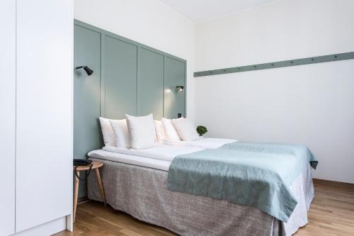 a bedroom with a large bed with white sheets and pillows at Biz Apartment Hammarby Sjöstad in Stockholm