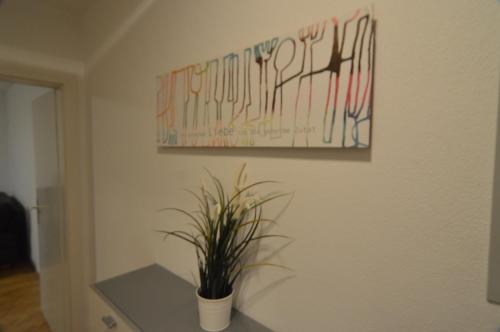 a plant on a table in a room with a painting at Pension Elisabeth - Rooms & Apartments in Salzburg