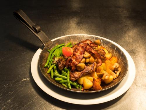 a pan of food with meat and vegetables on a table at Hotel Restaurant Schute in Emstek