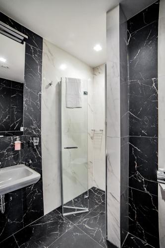 a bathroom with a glass shower and a sink at Hotel Wodnik in Bydgoszcz