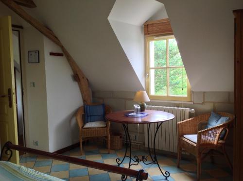 une pièce avec une table, des chaises et une fenêtre dans l'établissement Maison de vacances La Haute Cormerie, à Le Thoureil