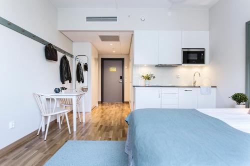 a kitchen and a bedroom with a bed and a table at Biz Apartment Hammarby Sjöstad in Stockholm
