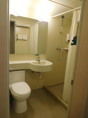 a bathroom with a toilet and a sink at Jinjiang Inn Beijing Liangxiang Nanguan Subway Station in Fangshan
