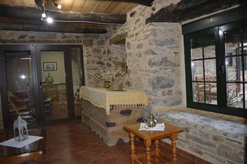 ein Wohnzimmer mit einer Steinmauer und einem Tisch in der Unterkunft La Casa de Rosa in Filiel