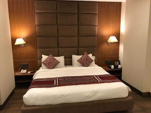 a bedroom with a large bed with a large headboard at The Royal Melange Beacon in Ajmer