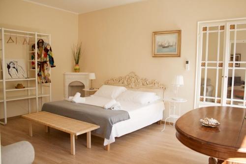 a bedroom with a white bed and a table at Acacia Firenze Apartments Artemisia-Angelica in Florence